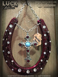 CRIMSON FAITH Luck Adorned Lucky Horseshoe is a stunning, deep burgundy-red shoe with that hammered texture that we just can't get enough of! It has a beautiful cross with a faux turquoise stone and red rubies as its centerpiece.